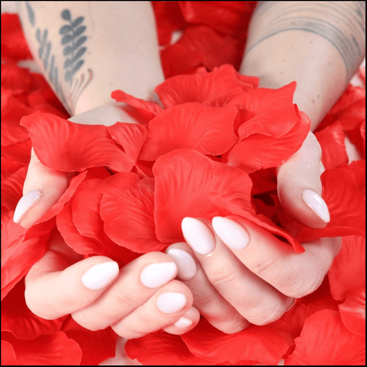 Hands holding lifelike red rose petals for romantic occasions and decorations.