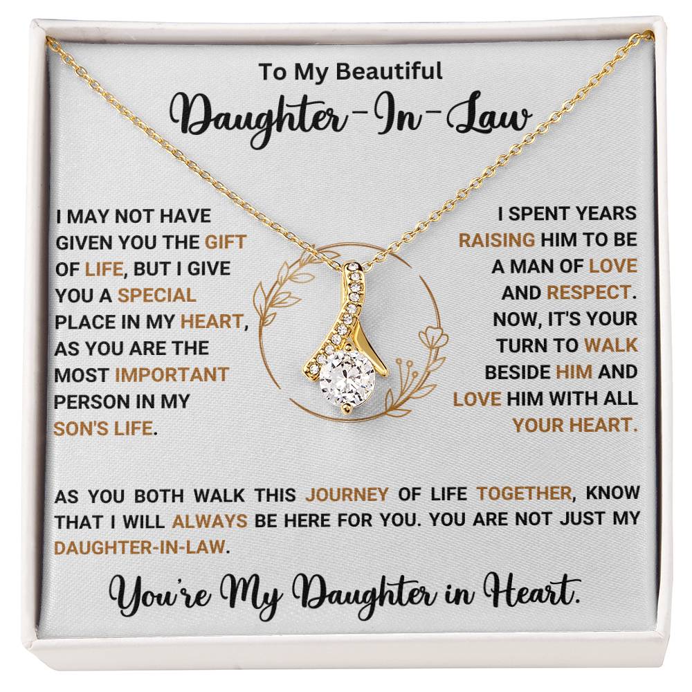 Gold necklace with ribbon-shaped pendant for daughter-in-law, set in an elegant gift box with loving message.