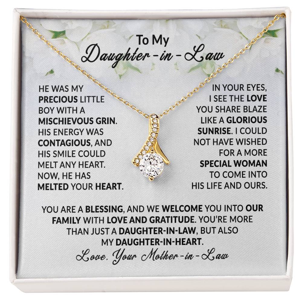 Alluring Beauty necklace with heartfelt message card for daughter-in-law, gold pendant on lush backdrop.