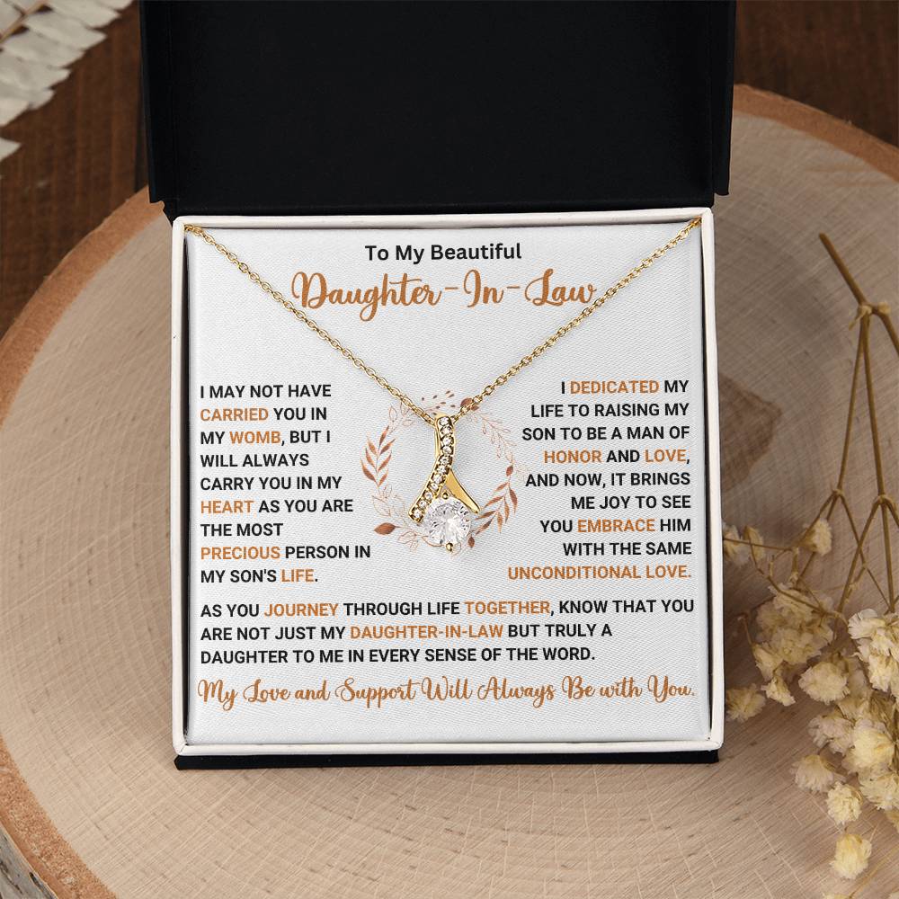 "To My Beautiful Daughter in Law necklace with heartfelt message in a gift box on a wooden surface"