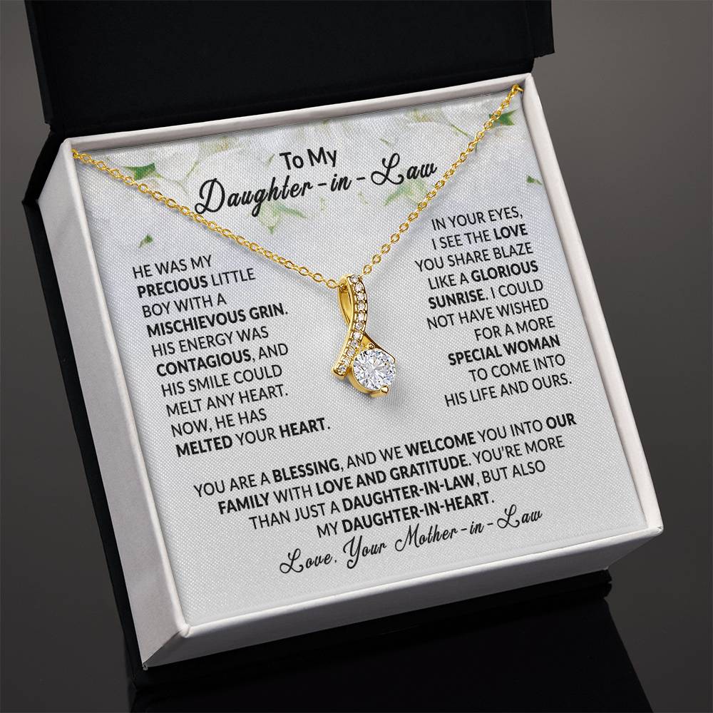 Alluring Beauty necklace in gold with ribbon pendant, displayed in gift box with heartfelt message for daughter-in-law.