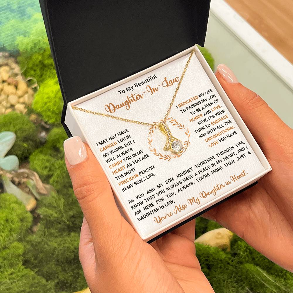 Necklace gift for daughter-in-law with heartfelt message, held by hands, surrounded by greenery. Perfect gift with 50% off and free shipping.