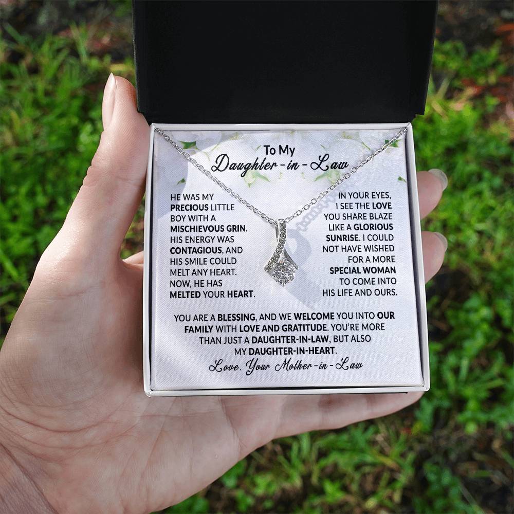 Alluring Beauty necklace with ribbon pendant, gift for daughter-in-law, displayed in an open box held by hand, heartfelt message inside.