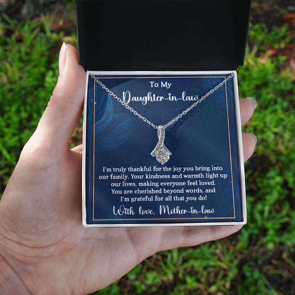 Hand holding Alluring Beauty necklace gift for daughter-in-law with heartfelt message.