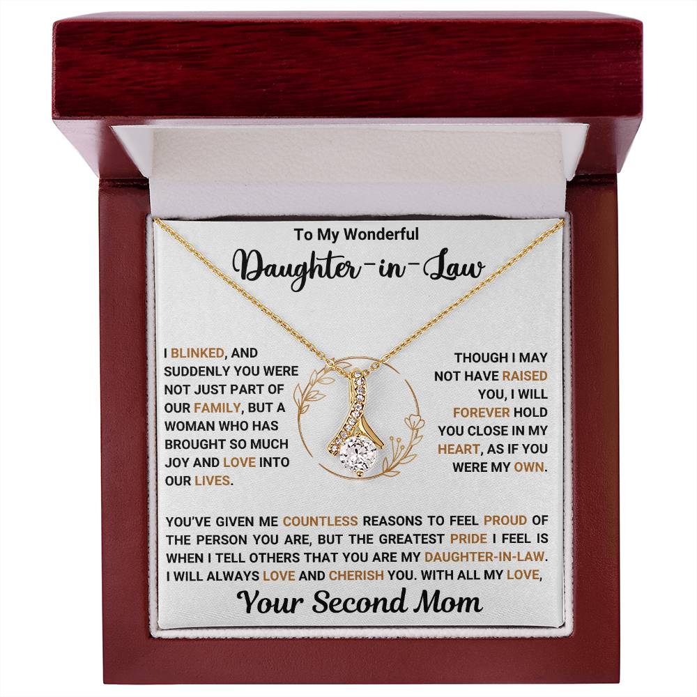 Alluring Beauty necklace with heartfelt message for daughter-in-law, featuring a gold ribbon-shaped pendant in a gift box.