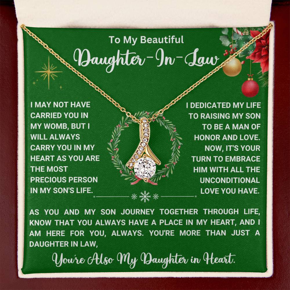 Elegant necklace with ribbon-shaped pendant on green card with heartfelt message for daughter-in-law, gift box background.