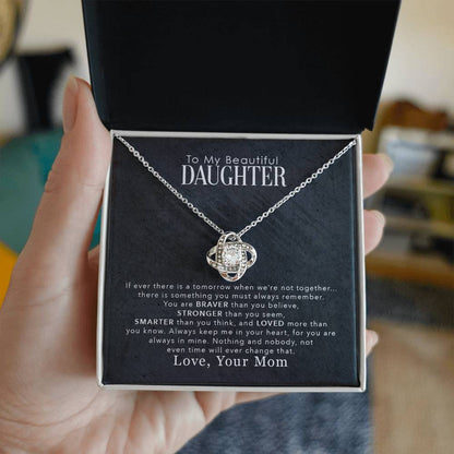 Love Knot Necklace with cubic zirconia for daughter, text reads "To My Beautiful Daughter, You Are Braver Than You Believe," held in hand