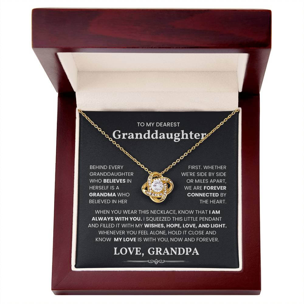 Gold love knot necklace gift with heartfelt message for granddaughter, displayed in an elegant wooden box