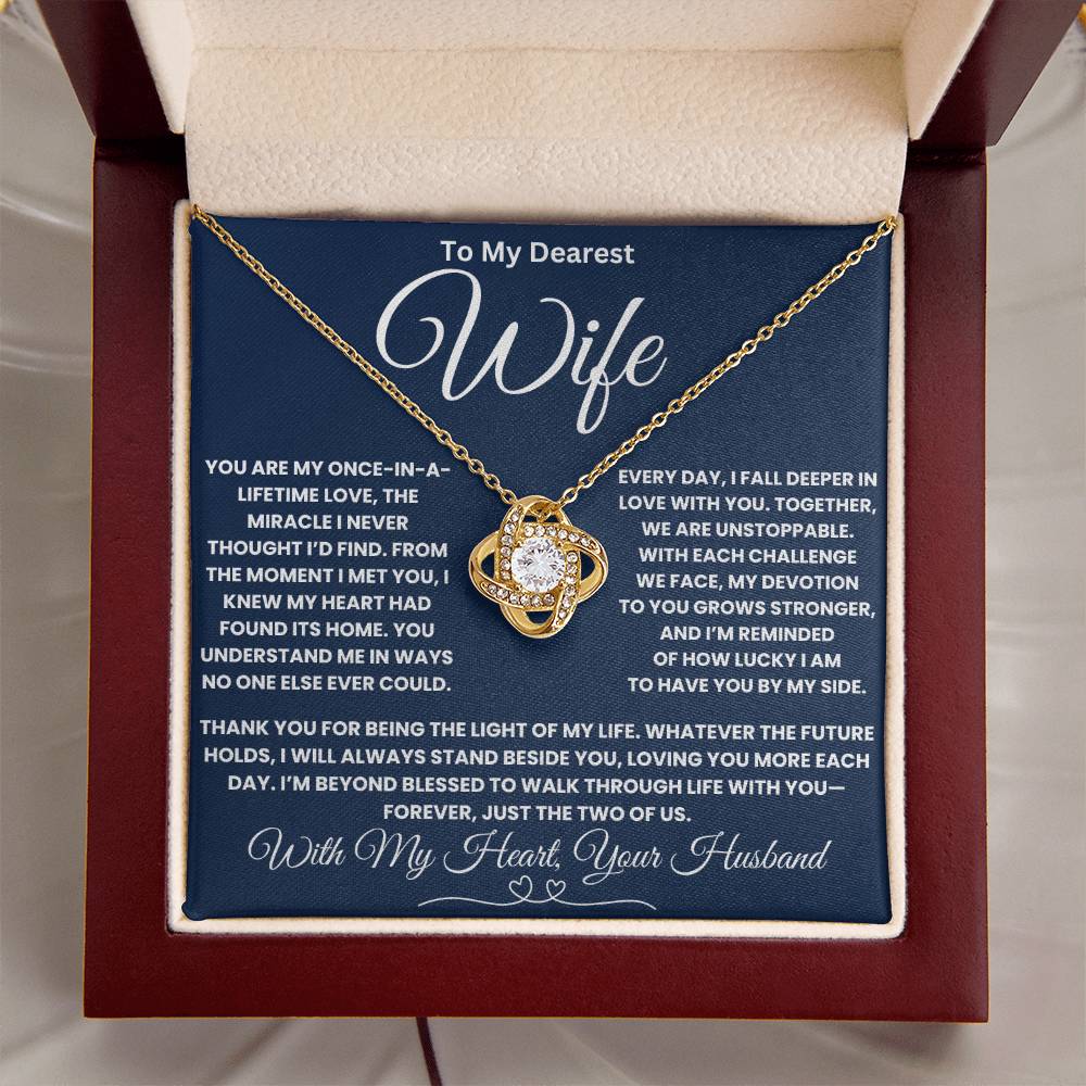 Gold love knot necklace on message card for wife, expressing deep love and appreciation, displayed in a jewelry box.