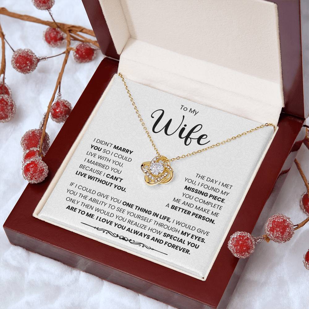 To My Wife Love Knot Necklace with heartfelt message in an elegant gift box surrounded by red decorative berries.