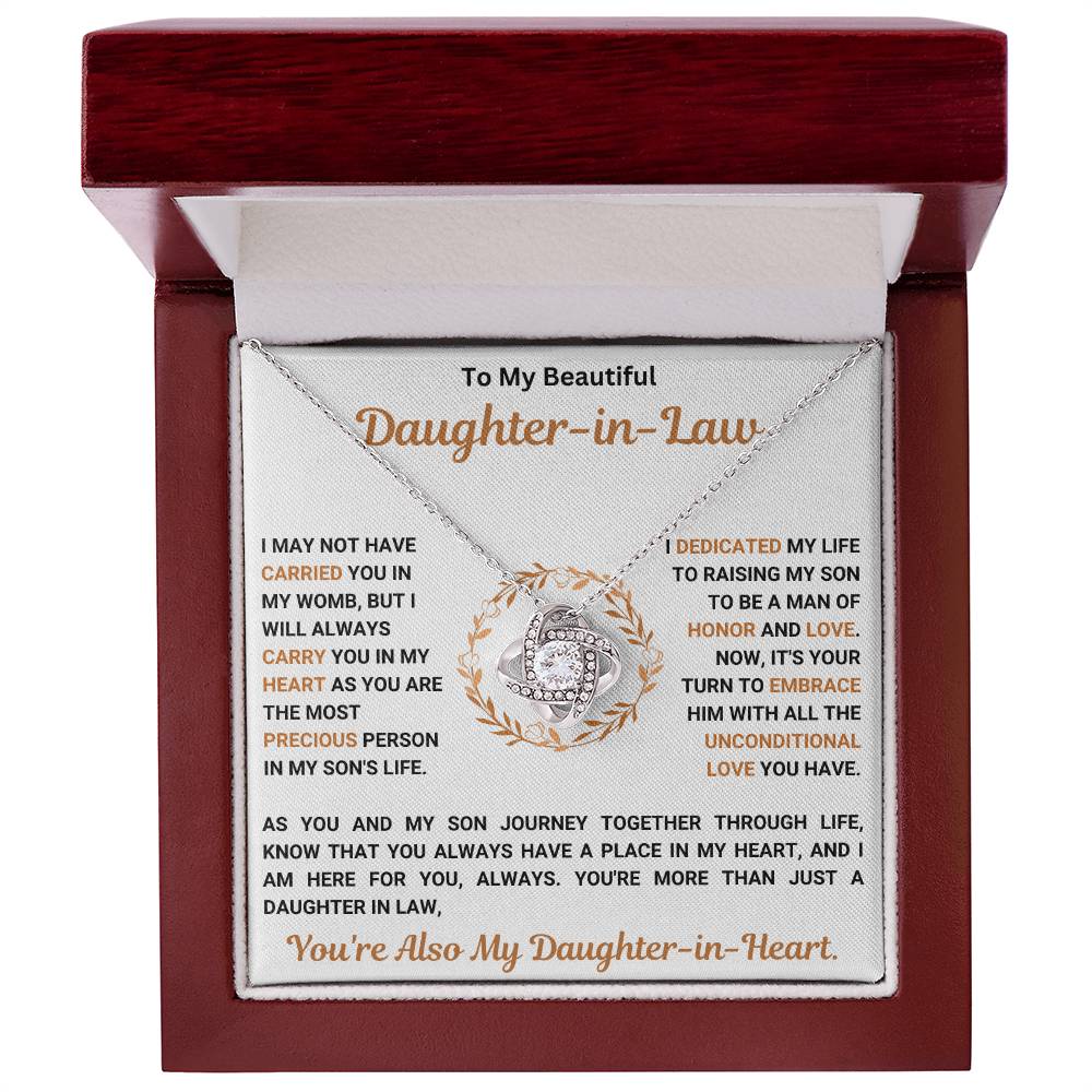 Love Knot Necklace in a wooden box with a heartfelt message for daughter-in-law. Elegant pendant with cubic zirconia on display.