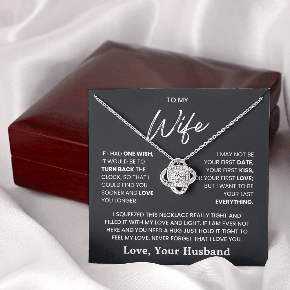 Love Knot Necklace for Wife with heartfelt message from husband on black card and wooden gift box background.