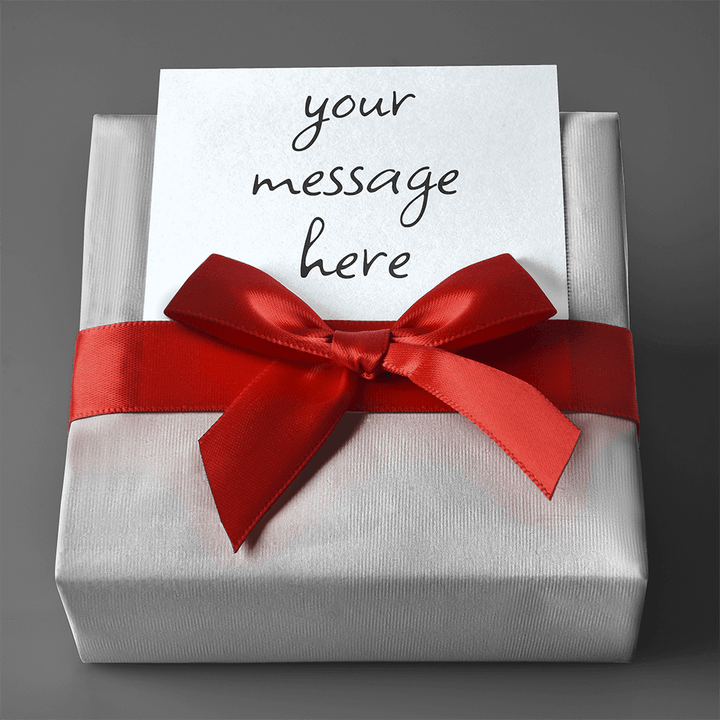 Custom gift wrapped in silver paper with a red ribbon and a personalized message card.