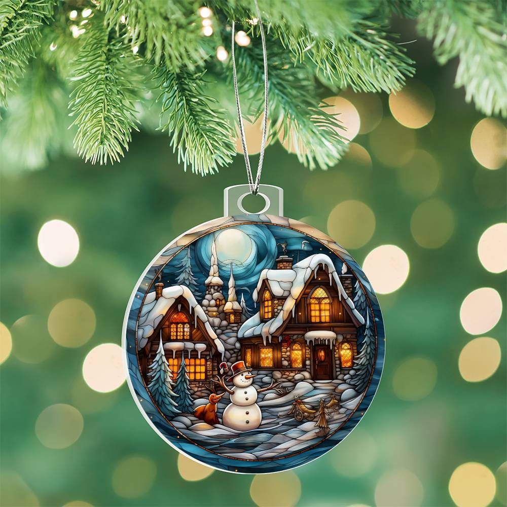 Snowy Cottage Christmas Charm ornament featuring cozy cottages, snowman, and moonlit winter scene, hanging on a tree branch.