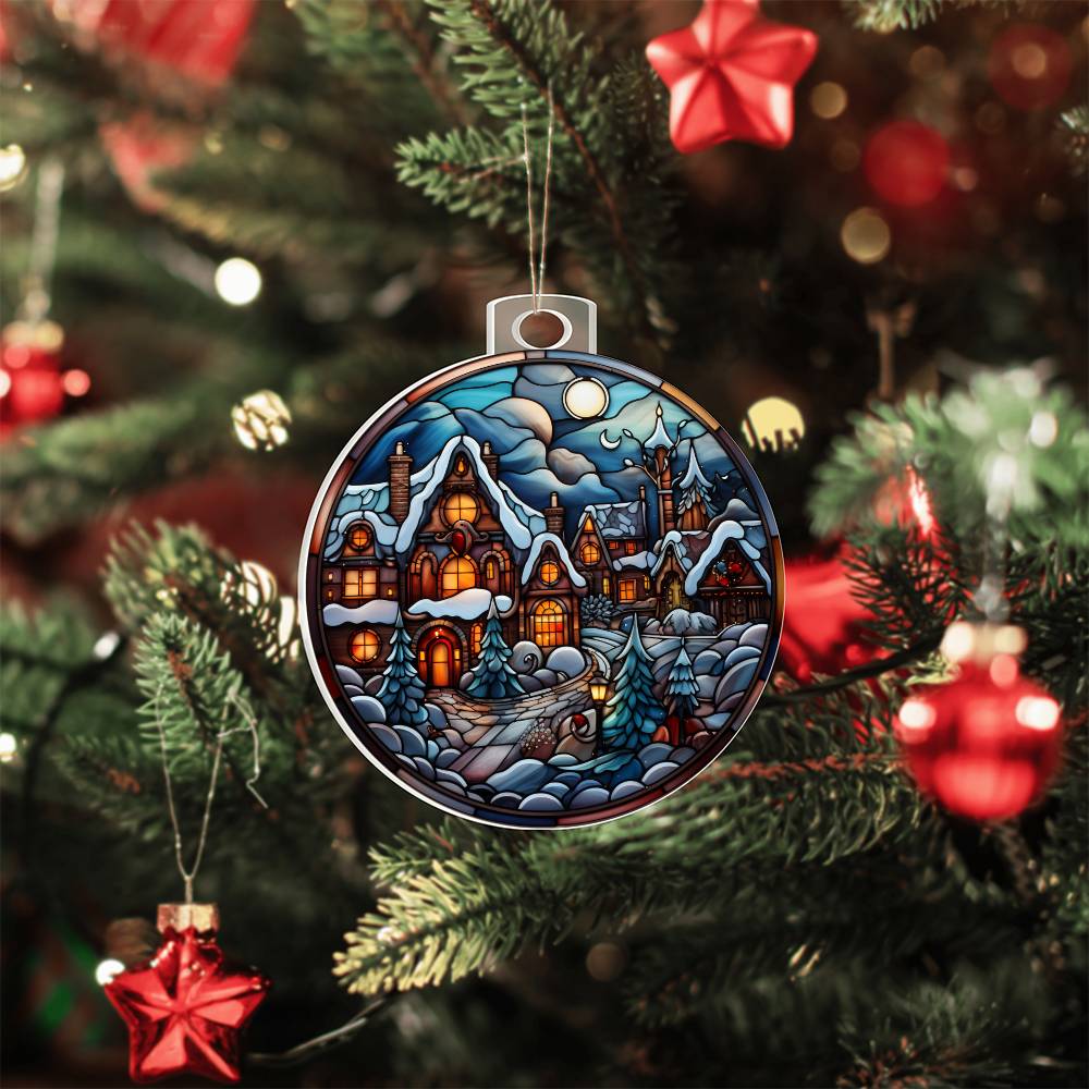 Christmas acrylic ornament featuring a moonlit village scene with cozy cottages, hanging on a decorated Christmas tree.