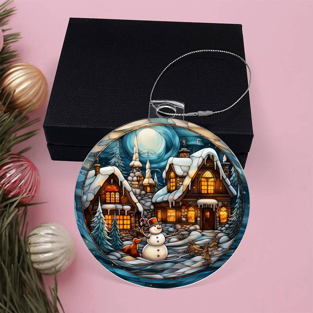 Snowy Cottage Christmas Charm acrylic ornament with snowman and village scene against a pink background, perfect for holiday decor.