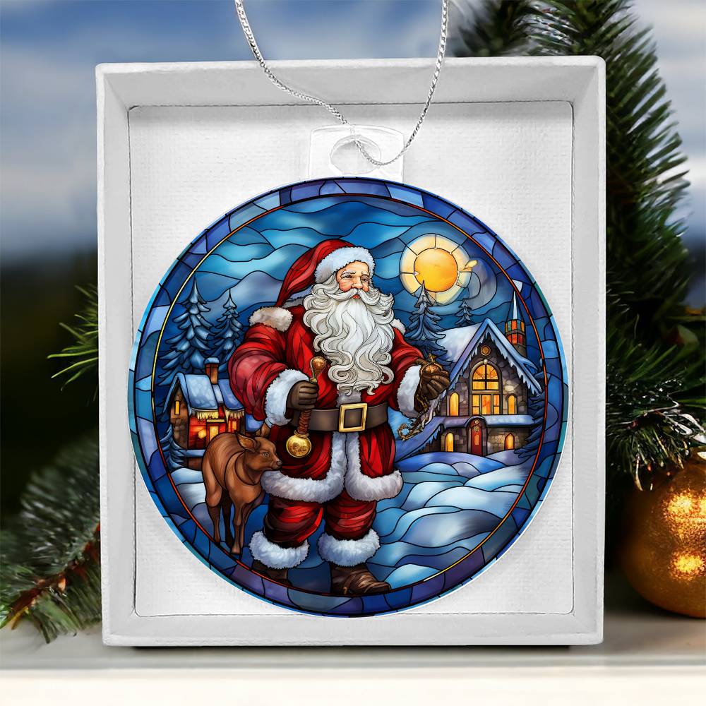 Christmas acrylic ornament featuring Santa with reindeer, cozy cabin, and snow-covered trees under a glowing sunset sky.