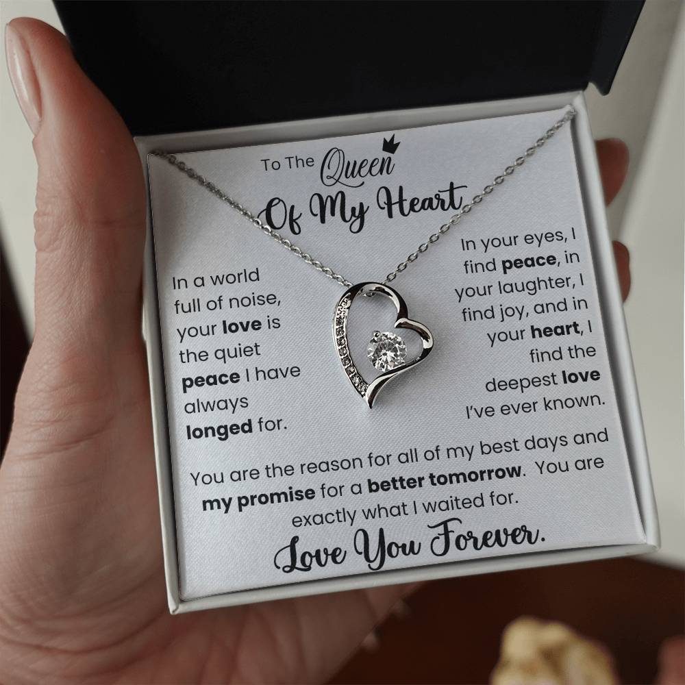 White gold Forever Love Necklace with CZ crystal heart pendant, held in hand, with jewelry box and heartfelt message card.