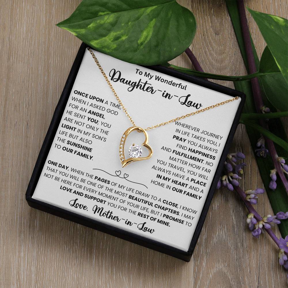 Gold heart necklace with a CZ crystal, in a box with a heartfelt message for daughter-in-law from mother-in-law on a wooden background